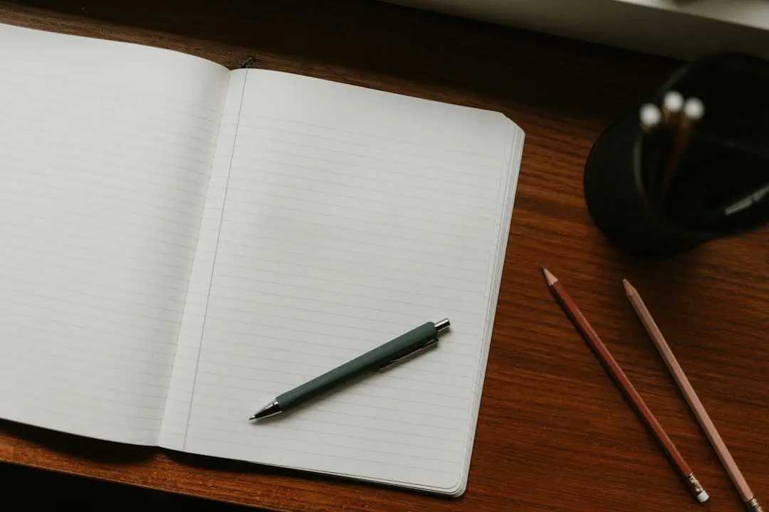 An open lined notebook with a pen and two pencils on a wooden desk, ready for a checklist to compare IPTV services like Flixaria